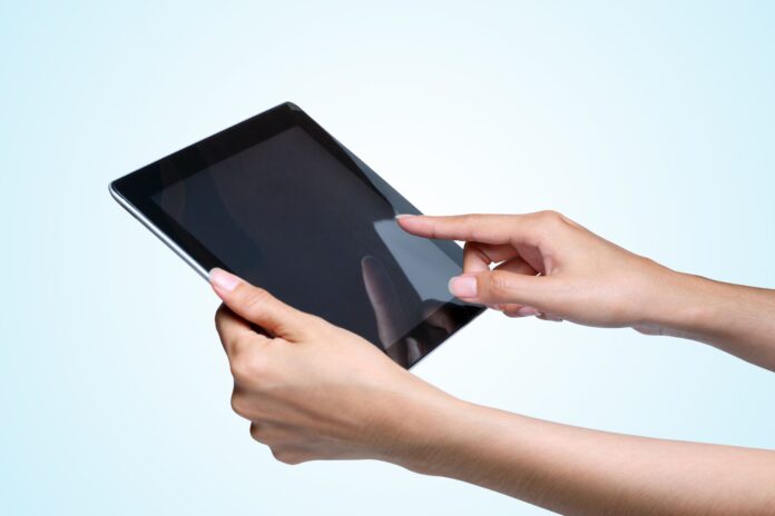 15415164 - female hands holding a tablet pc on blue background