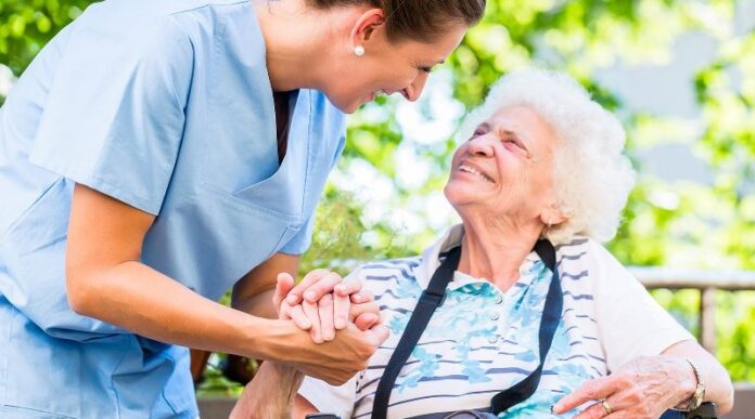 Nurse holding hand of senior woman in pension home
