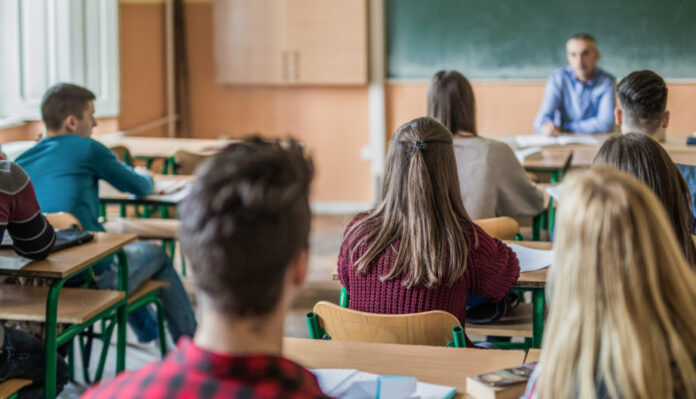 Rear view of high school students attending a class.